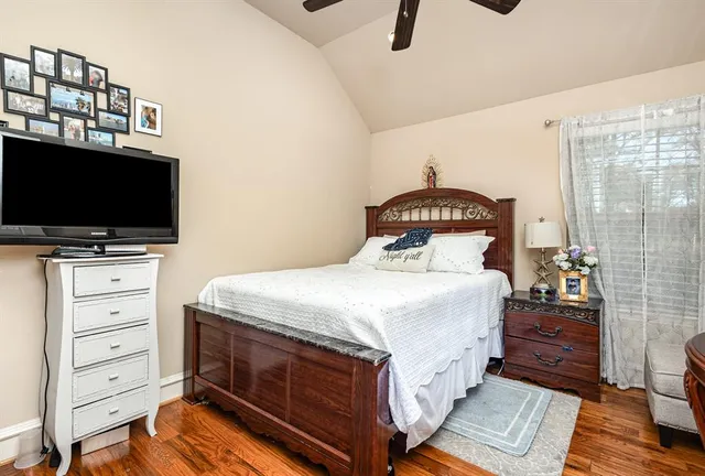 a bedroom with a bed and a flat tv screen on wall