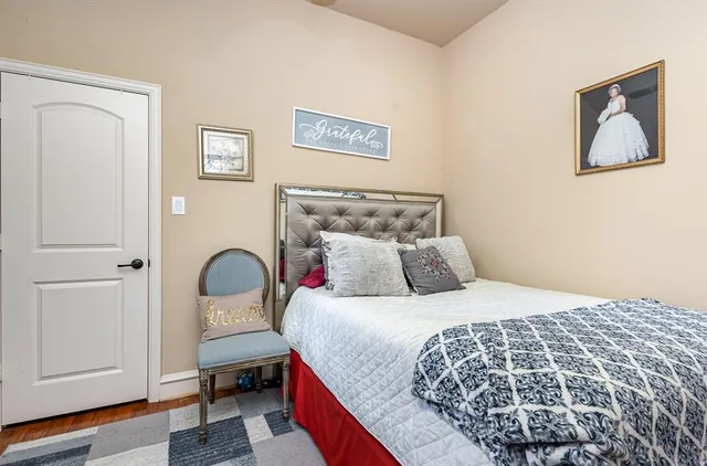 a bedroom with a bed and painting on the wall