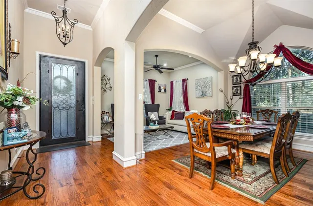 a dining room with furniture a chandelier and wooden floor