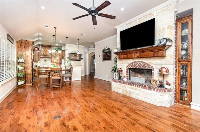 a living room with furniture a flat screen tv and a fireplace