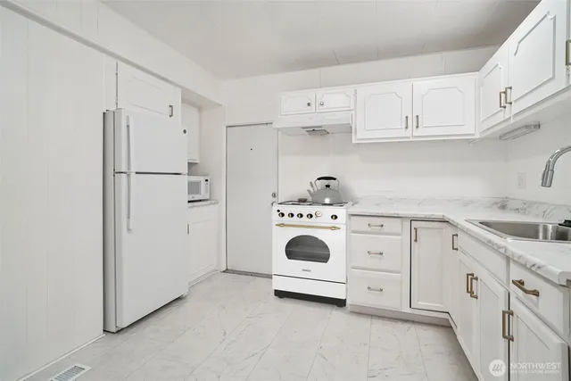 a kitchen with cabinets and white appliances