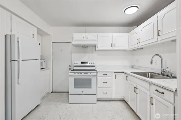 a kitchen with white cabinets stainless steel appliances and sink