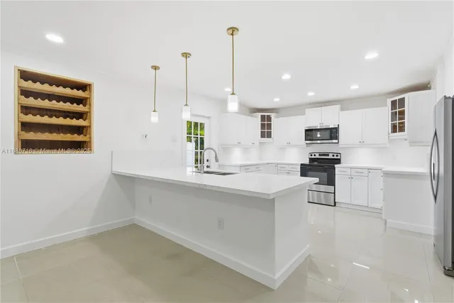 a kitchen with white cabinets and sink