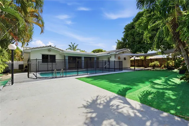 a view of a house with a small yard and a large tree