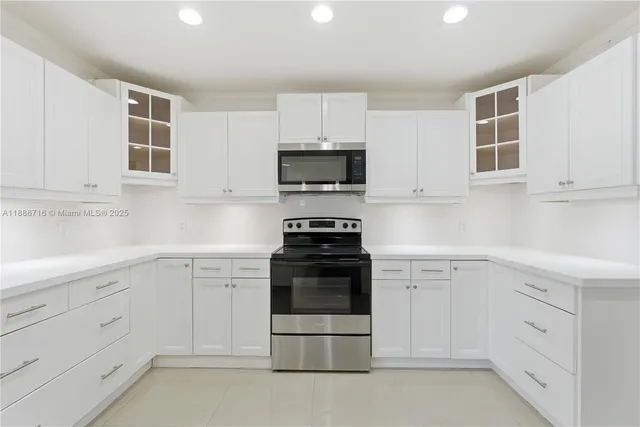 a kitchen with white cabinets and appliances