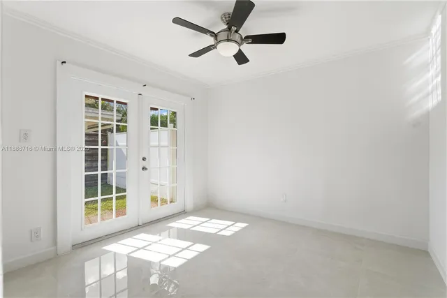 an empty room with windows and ceiling fan