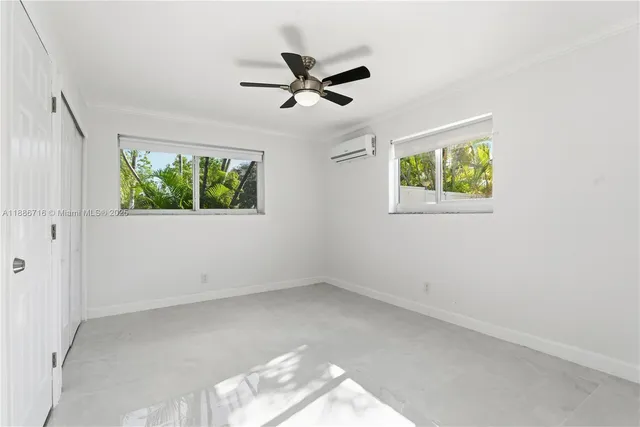 an empty room with windows and closet