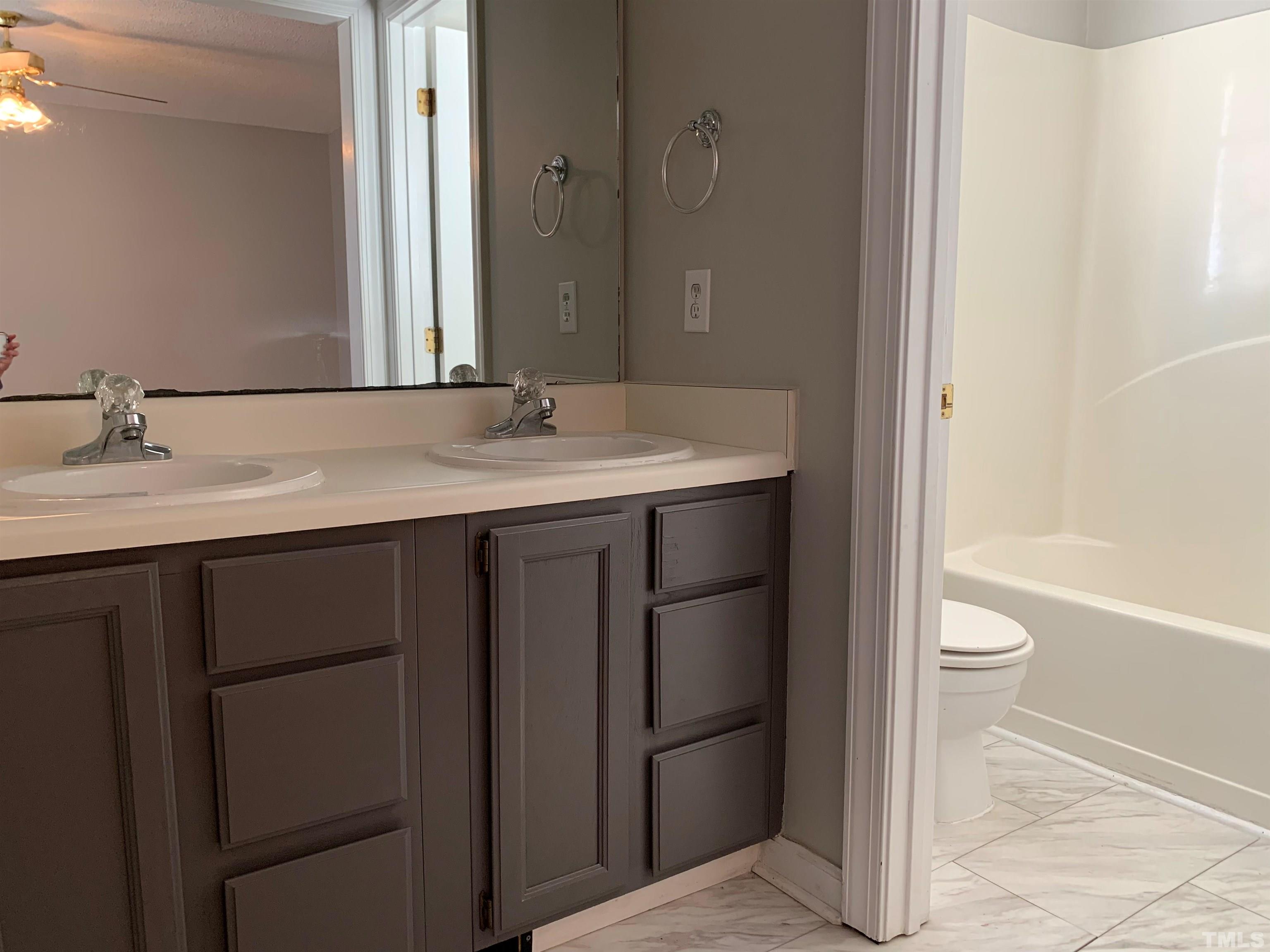 2316 Rolesville Road Wake Forest, NC 27587 - Photo 11 of 17 a bathroom with a sink a toilet and a large mirror