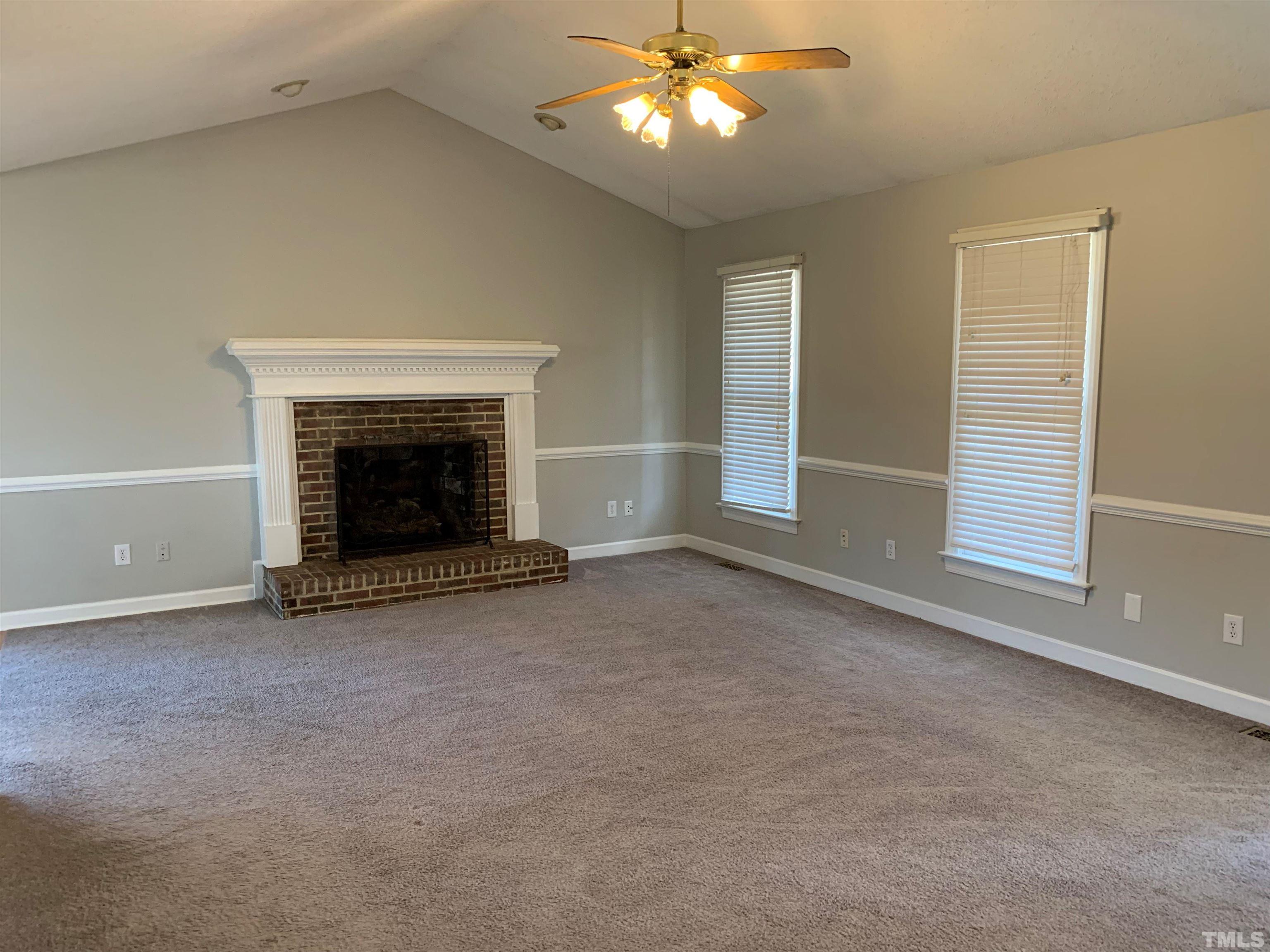 2316 Rolesville Road Wake Forest, NC 27587 - Photo 3 of 17 an empty room with windows fireplace and fan