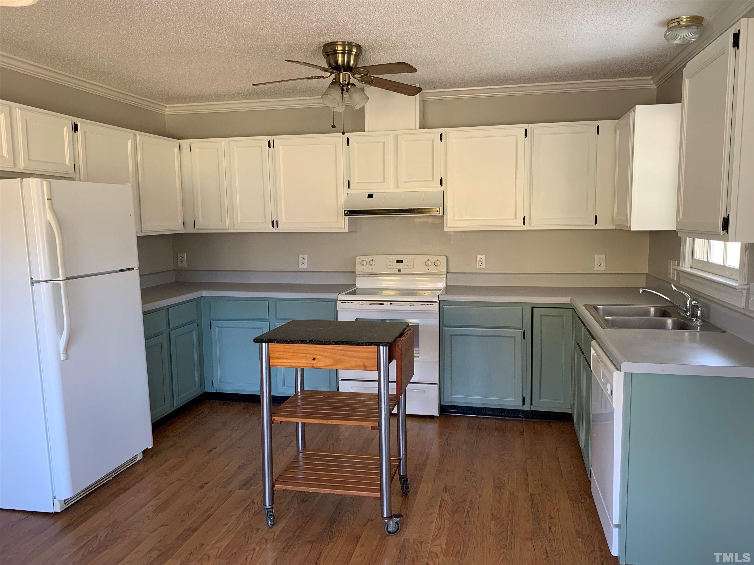 2316 Rolesville Road Wake Forest, NC 27587 - Photo 5 of 17 a kitchen with a sink a stove a refrigerator and white cabinets
