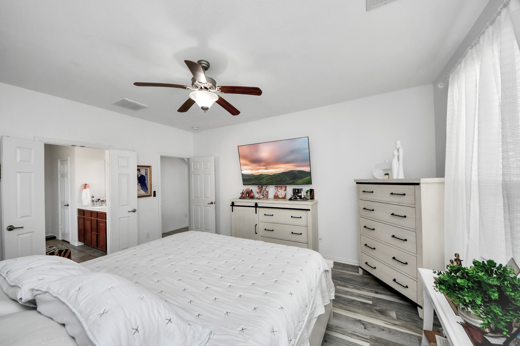 12119 Redbud Brook Trail Houston, TX 77089 - Photo 32 of 48 a bedroom with a bed a dresser and a chandelier