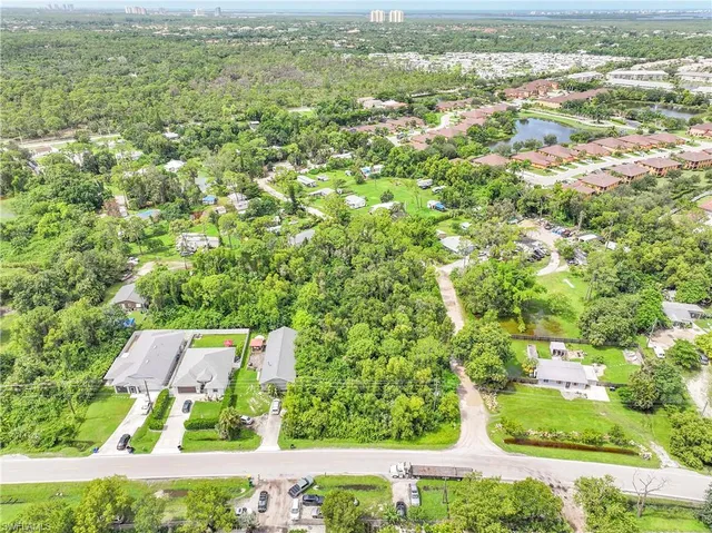 an aerial view of residential houses with outdoor space and trees