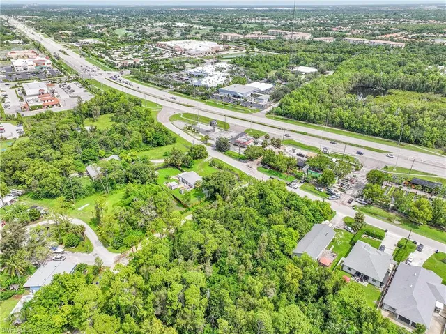 an aerial view of residential houses with outdoor space and trees