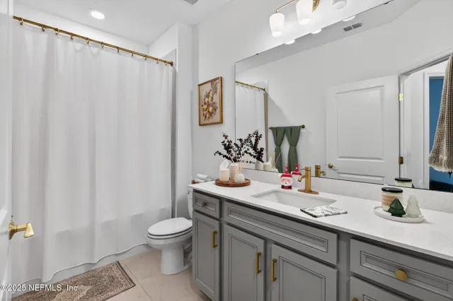 a bathroom with a double vanity sink toilet and a mirror