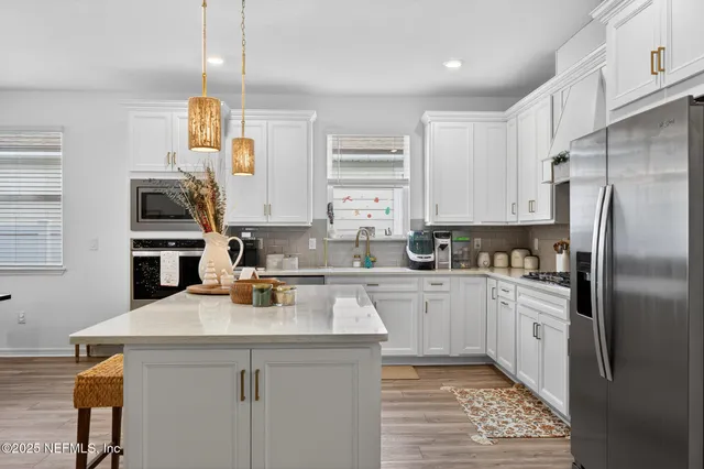 a kitchen with a sink stainless steel appliances and white cabinets