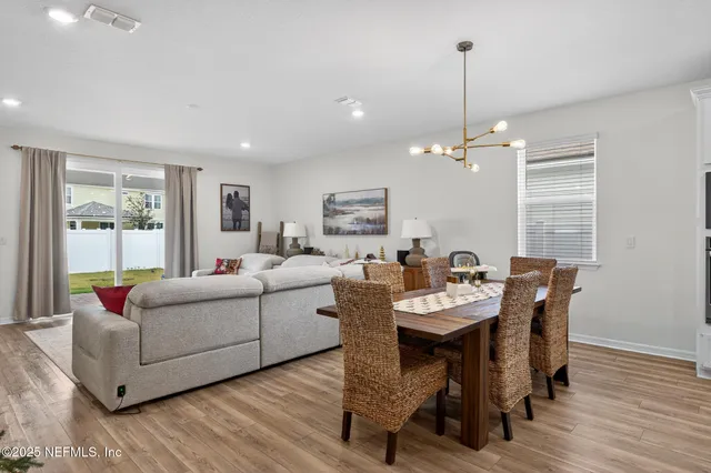 a living room with furniture a dining table and a wooden floor