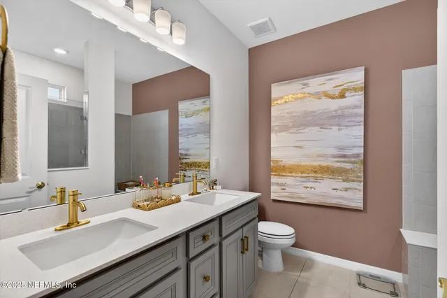 a bathroom with a granite countertop sink toilet a large mirror and shower