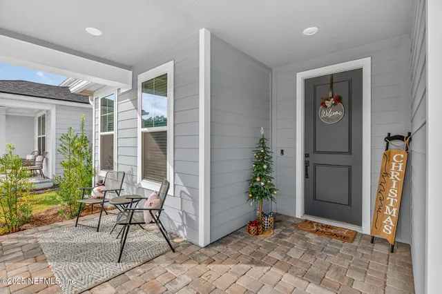 a view of a porch with chairs and potted plants