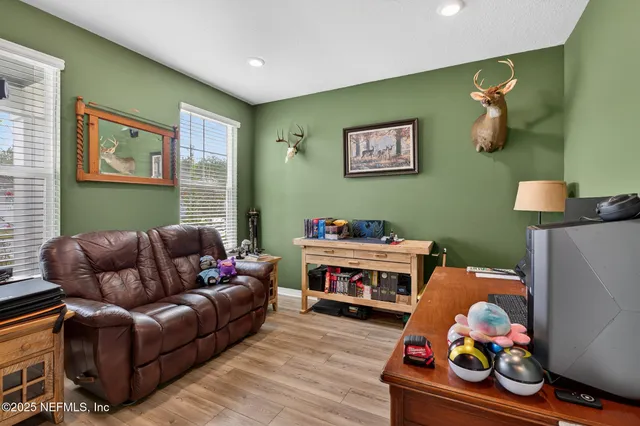 a living room with furniture and a baby crib