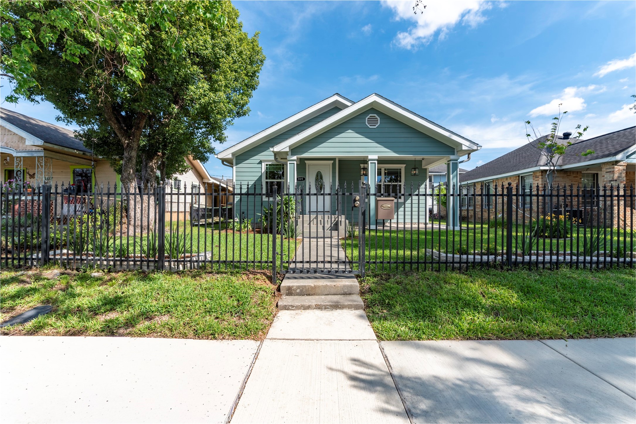 109 Dresden Street Houston, TX 77012 - Photo 2 of 43 Charming single-story home with a welcoming front porch, lovely exterior, and well-maintained lawn. Features a fenced yard and mature trees, offering privacy and curb appeal.