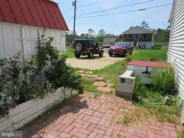 a view of a chair and table in backyard of the house