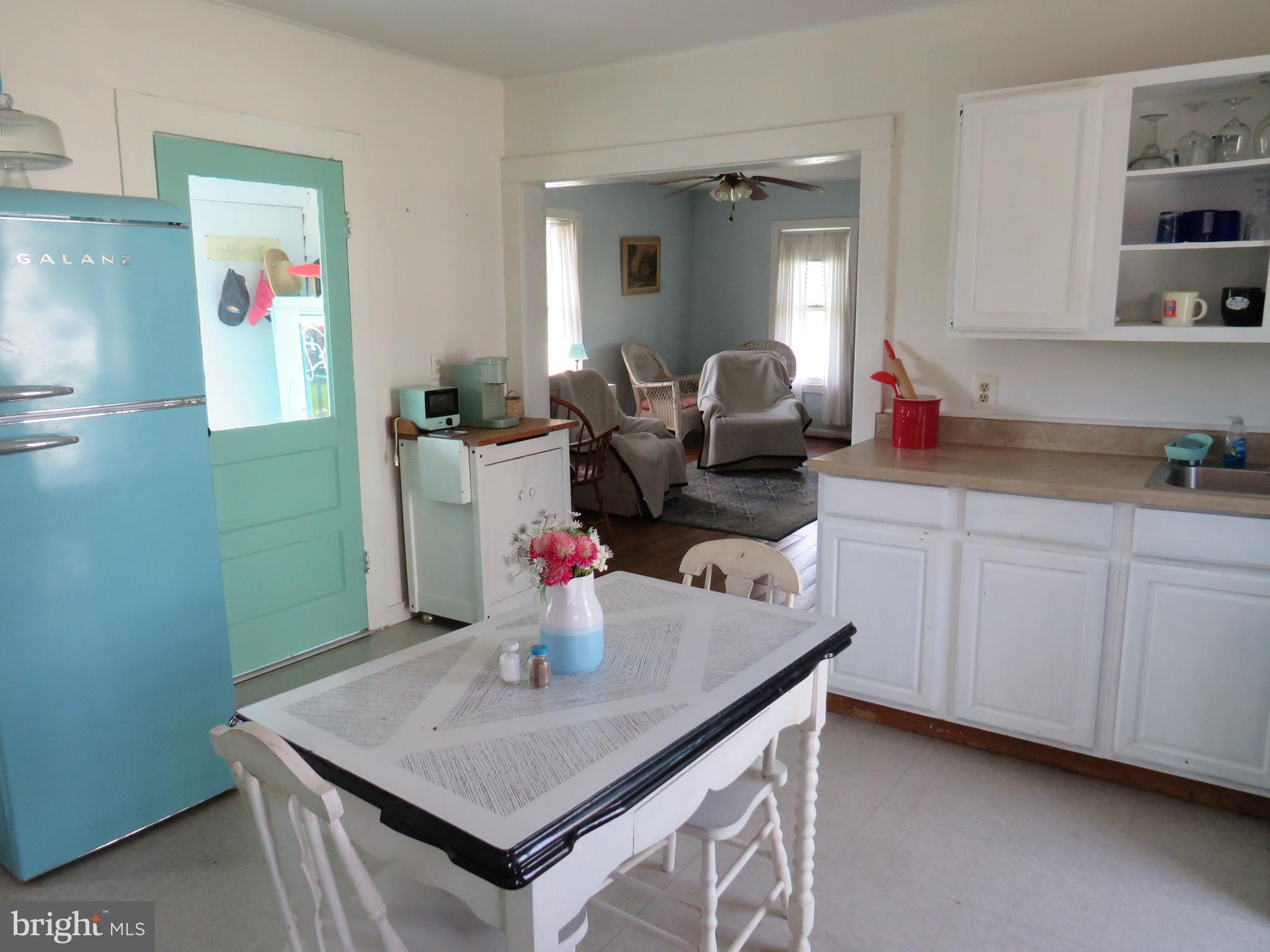 3289 Sackertown Road Crisfield, MD 21817 - Photo 8 of 25 a kitchen with a sink dishwasher and a refrigerator with white cabinets