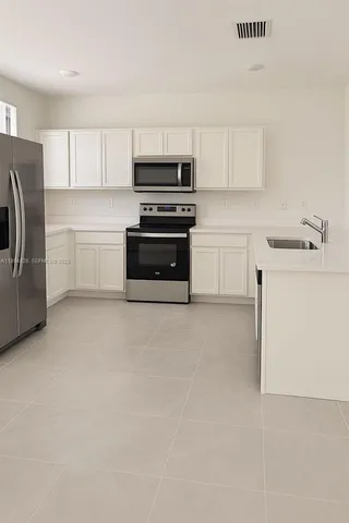 a kitchen with cabinets and steel appliances