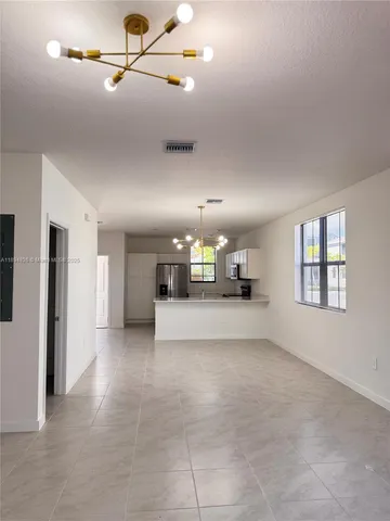 a view of a hallway with a livingroom and furniture