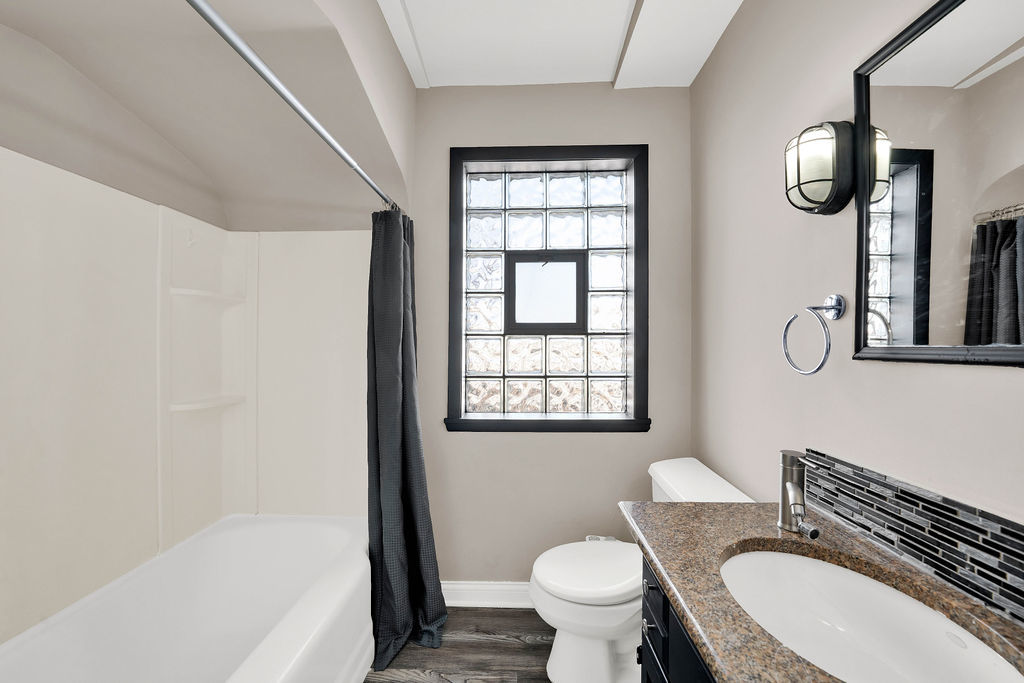 6559 South Kilpatrick Avenue Chicago, IL 60629 - Photo 13 of 26 a bath room with a toilet a sink and a bath tub