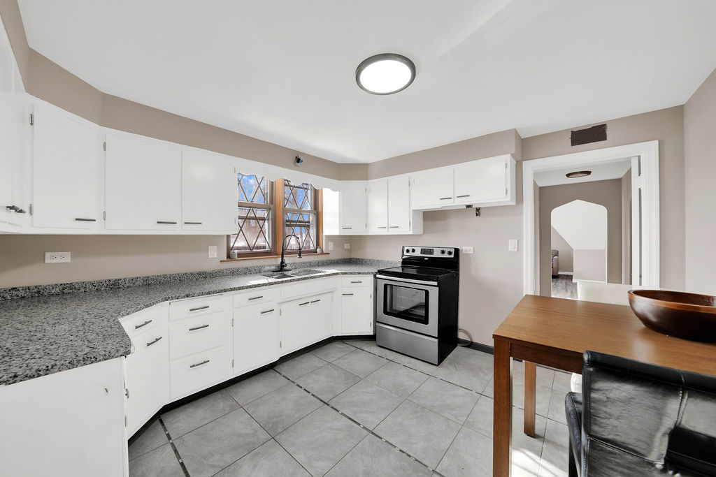 6559 South Kilpatrick Avenue Chicago, IL 60629 - Photo 17 of 26 a kitchen with granite countertop a sink stove and refrigerator