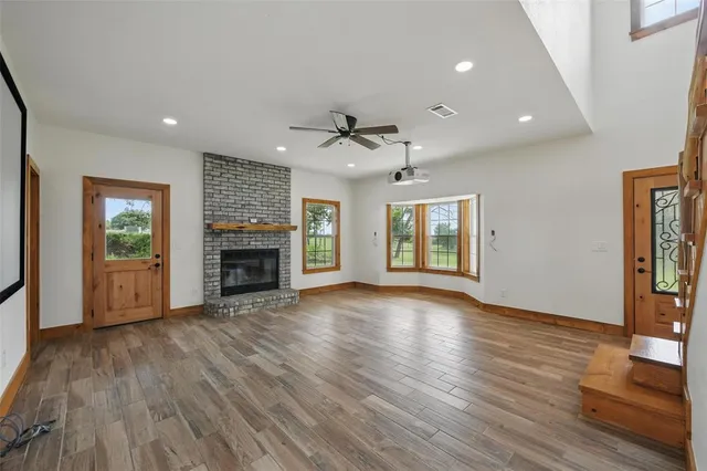 a view of an empty room with a fireplace and a window