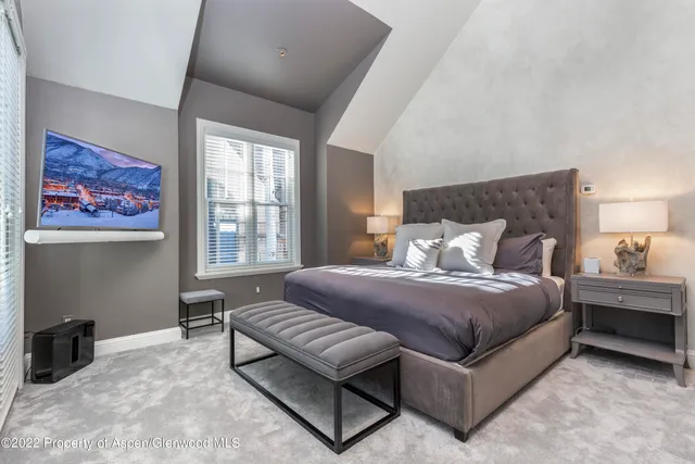 a spacious bedroom with a bed and a window