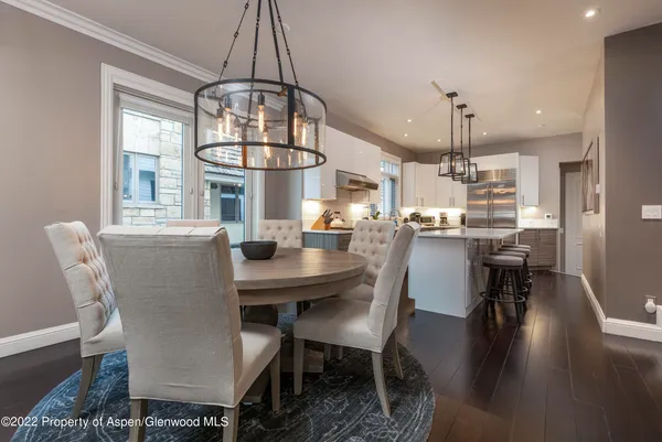 a dining room with furniture a chandelier and wooden floor