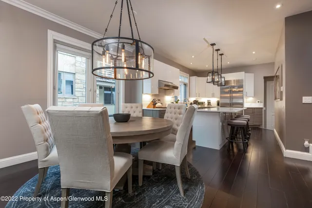 a dining room with furniture a chandelier and wooden floor