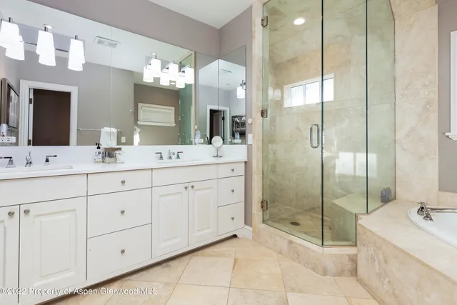 a bathroom with a double vanity sink mirror and shower