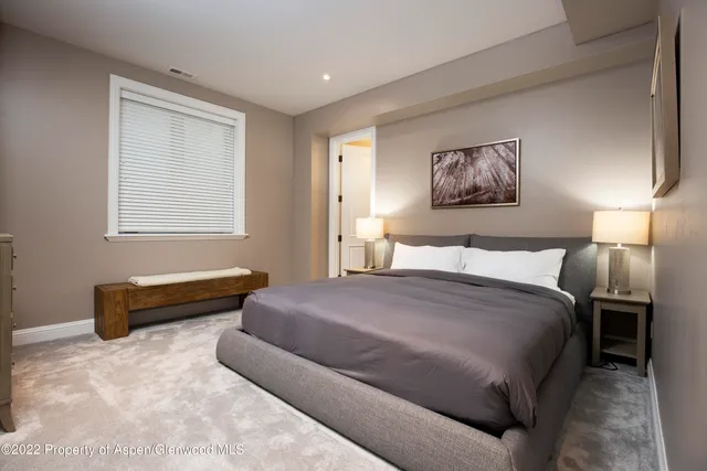 a spacious bedroom with a bed and a window