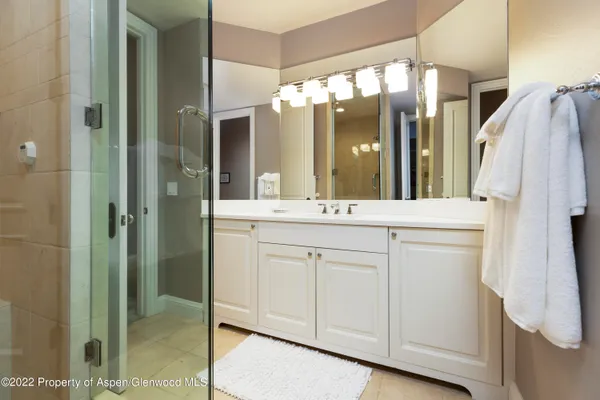 a bathroom with a double vanity sink mirror and shower
