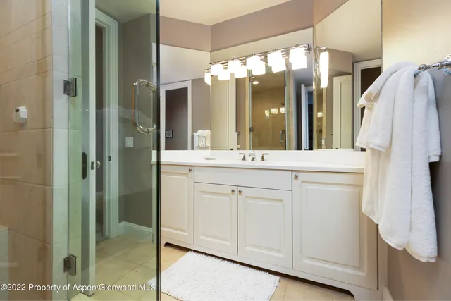 a bathroom with a double vanity sink mirror and shower