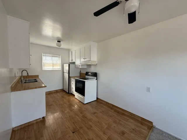 a kitchen with granite countertop a sink cabinets and stainless steel appliances