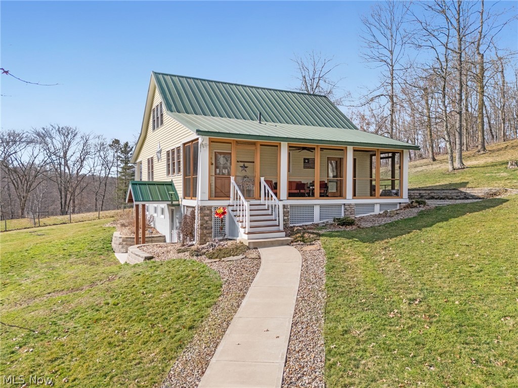 View of front with a screened in porch and a metal roof