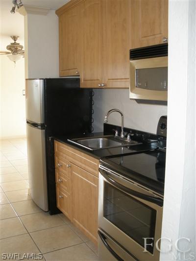 8162 Country Road, Unit 206 Fort Myers, FL 33919 - Photo 2 of 7 a kitchen with granite countertop a stove and a microwave