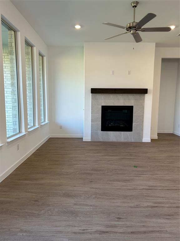 148 Breeds Hl Road Little Elm, TX 75068 - Photo 3 of 20 a view of empty room with wooden floor and a fireplace