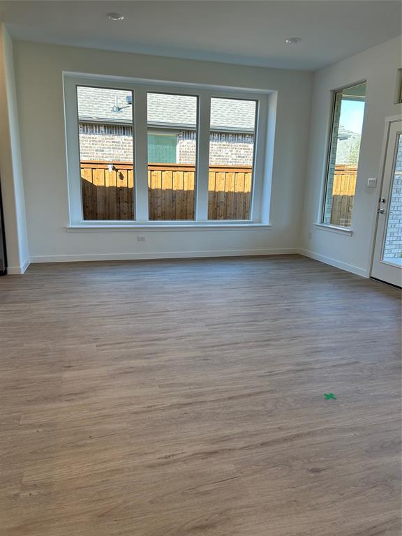 148 Breeds Hl Road Little Elm, TX 75068 - Photo 4 of 20 a view of an empty room with window and wooden floor