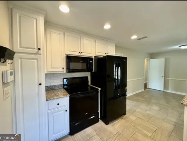 a kitchen with granite countertop a sink and cabinets