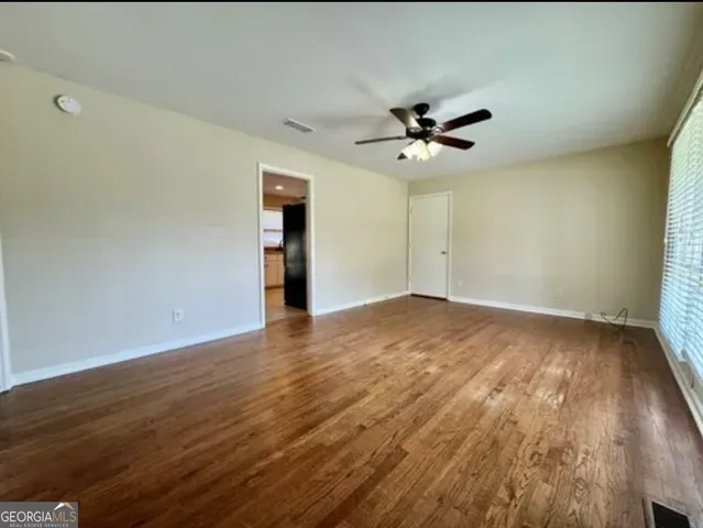 an empty room with wooden floor and a window