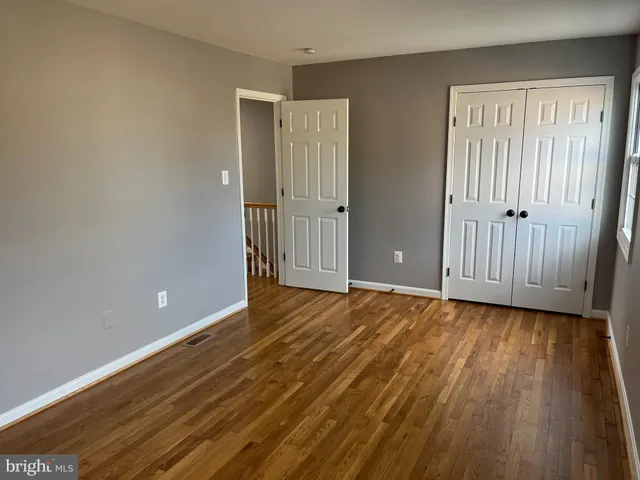 a view of an empty room with wooden floor