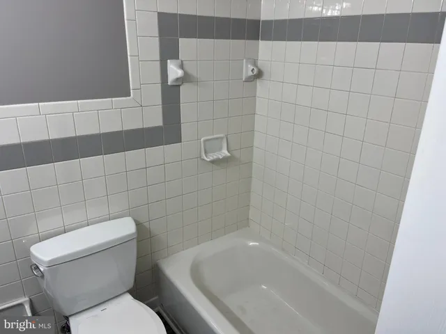 a white toilet sitting next to a bath tub
