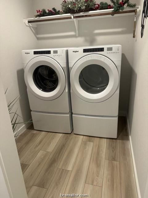 1206 Amistad Loop College Station, TX 77845 - Photo 10 of 11 Laundry area featuring washing machine and clothes dryer and light wood-type flooring
