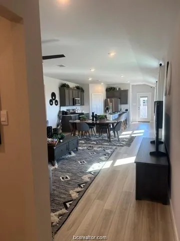 a kitchen with stainless steel appliances granite countertop a sink stove and view of living room