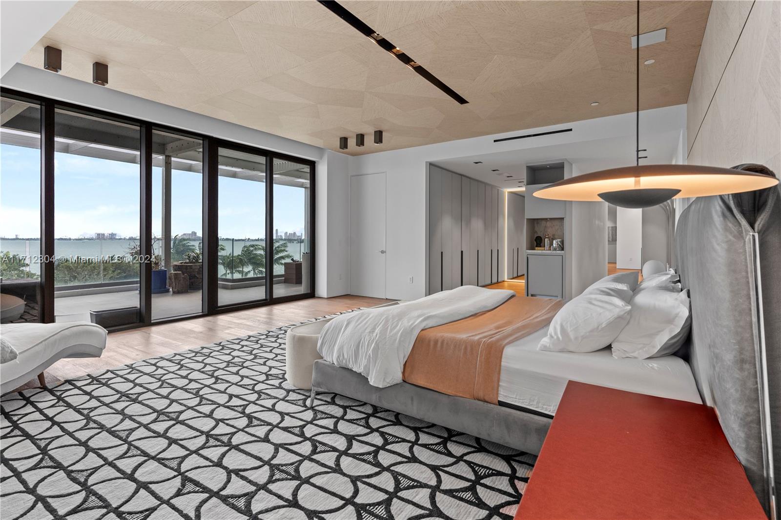 650 Northeast 32nd Street, Unit BH2 Miami, FL 33137 - Photo 11 of 30 a bedroom with a large bed and a chandelier